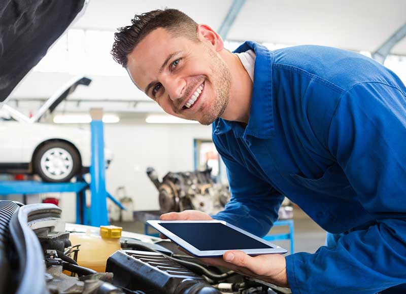 Service man smiling over car